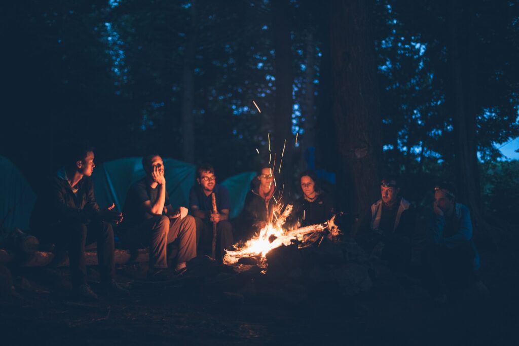 A group of friends sitting around a campfire telling stories.